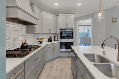 a kitchen with a sink a stove and cabinets