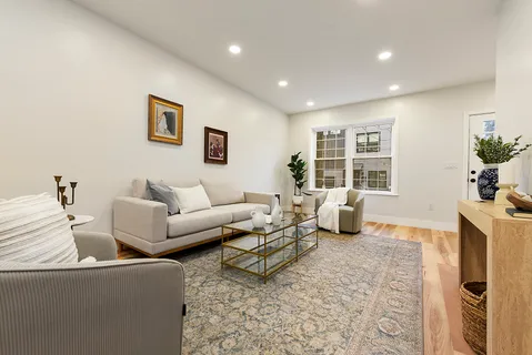 a living room with furniture a fireplace and a potted plant