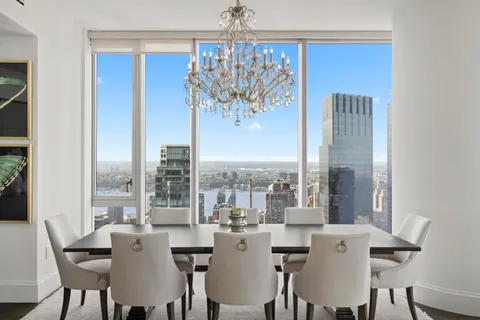 a view of a dining room with furniture large windows and wooden floor