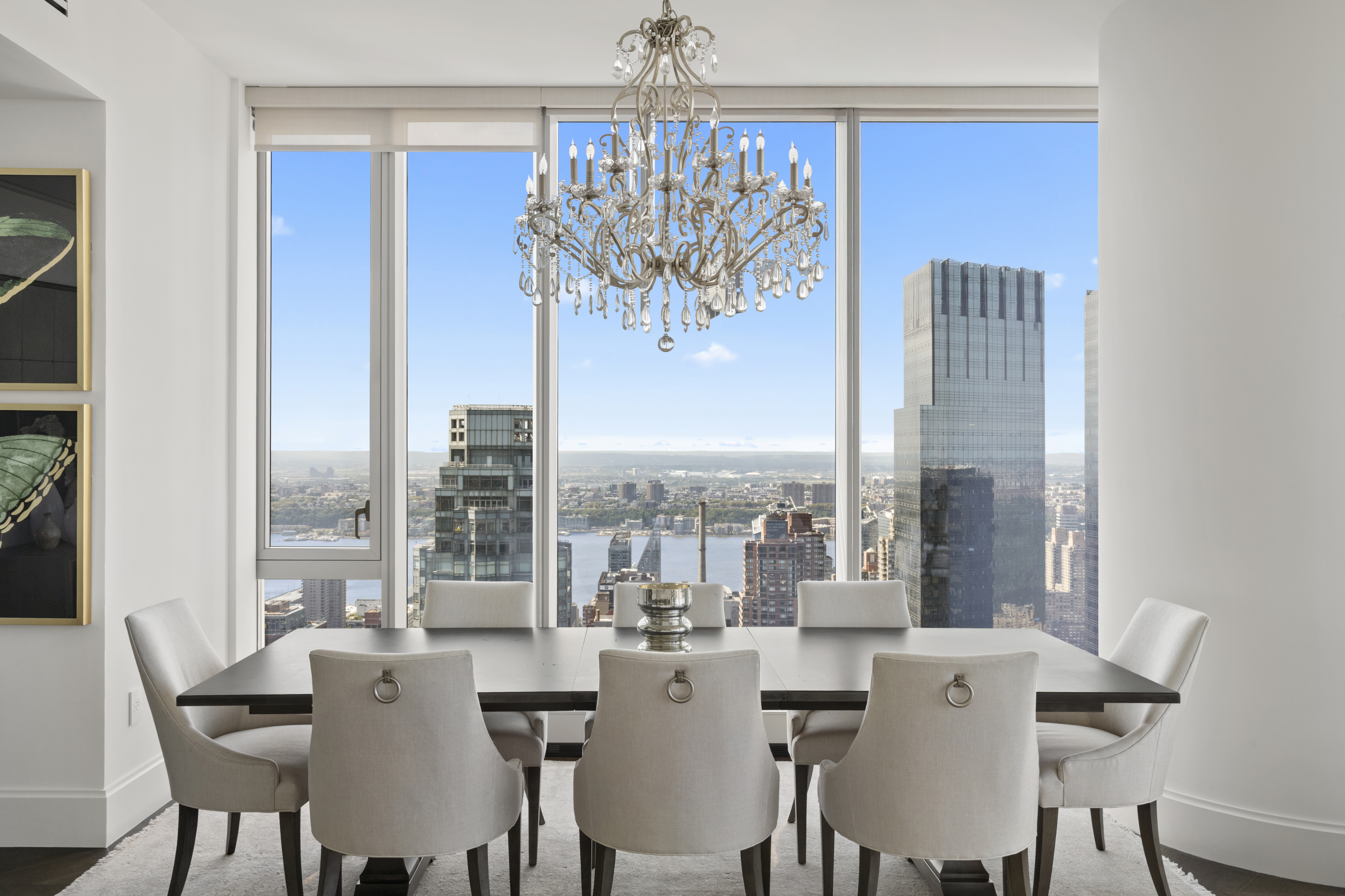 217 West 57th Street, Unit 58W Manhattan, NY 10019 - Photo 4 of 30 a view of a dining room with furniture large windows and wooden floor