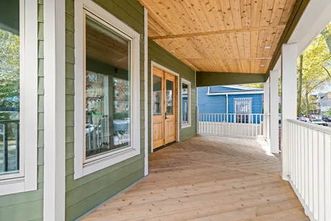 a view of porch with a floor to ceiling window and wooden floor
