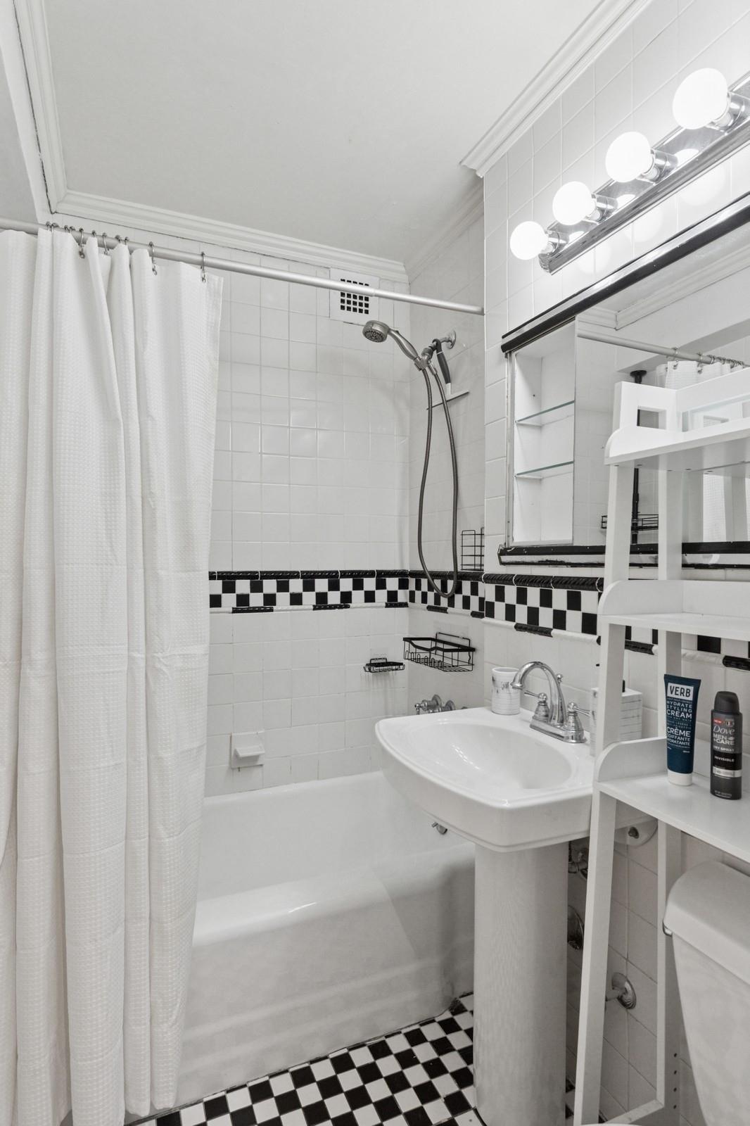 301 East 22nd Street, Unit 11U Manhattan, NY 10010 - Photo 7 of 11 a bathroom with a sink a mirror a bathtub and shower
