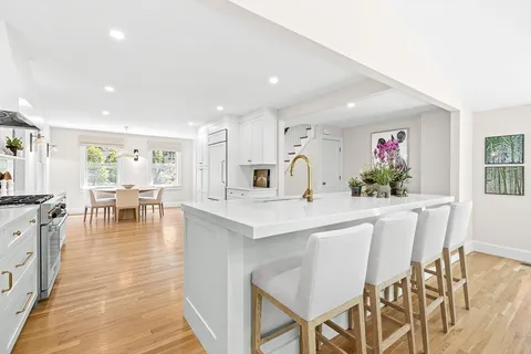 a kitchen with stainless steel appliances kitchen island granite countertop a table and chairs in it