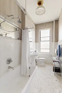 a bathroom with a tub sink and mirror