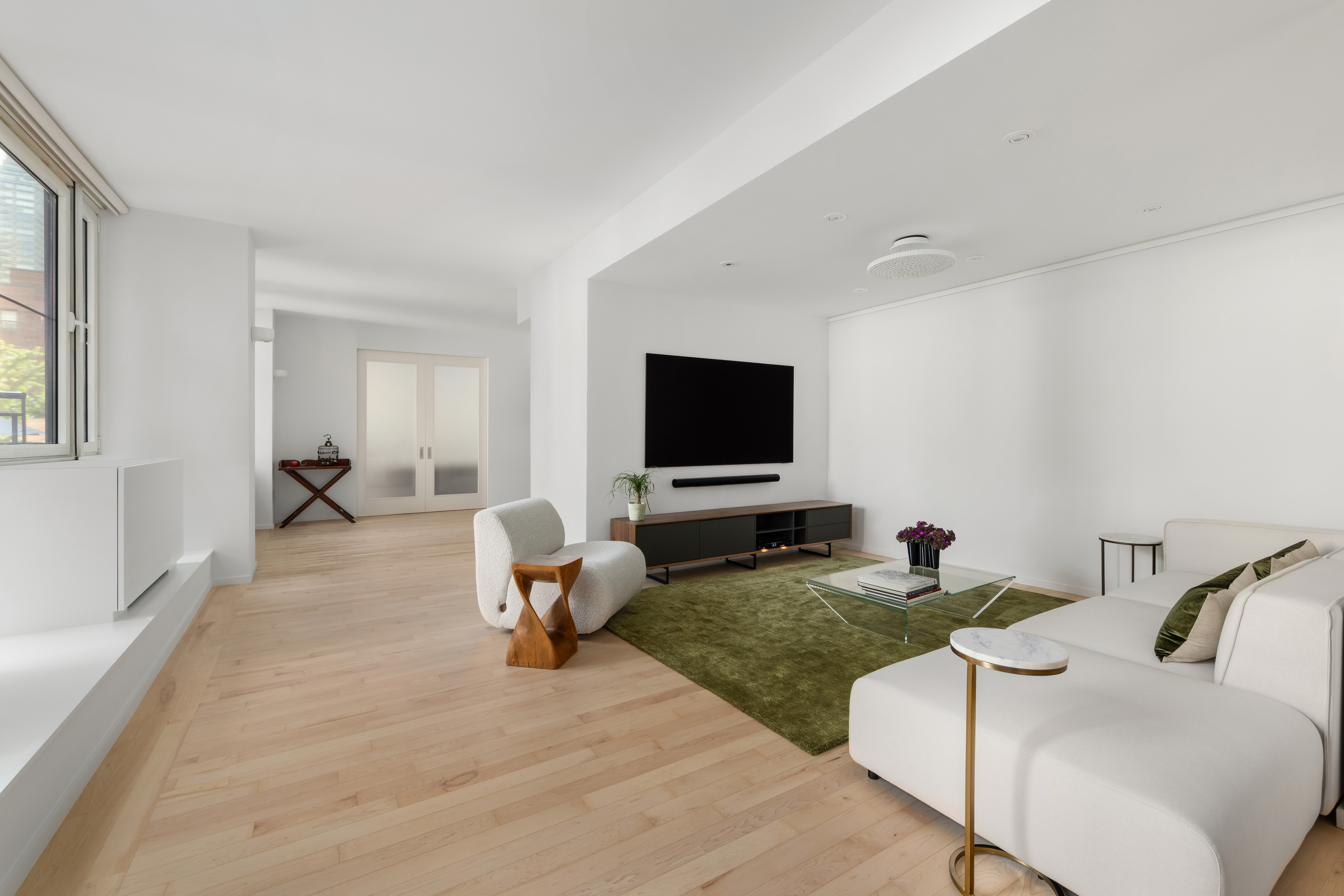 404 East 76th Street, Unit 2B Manhattan, NY 10021 - Photo 6 of 24 a living room with furniture and a flat screen tv