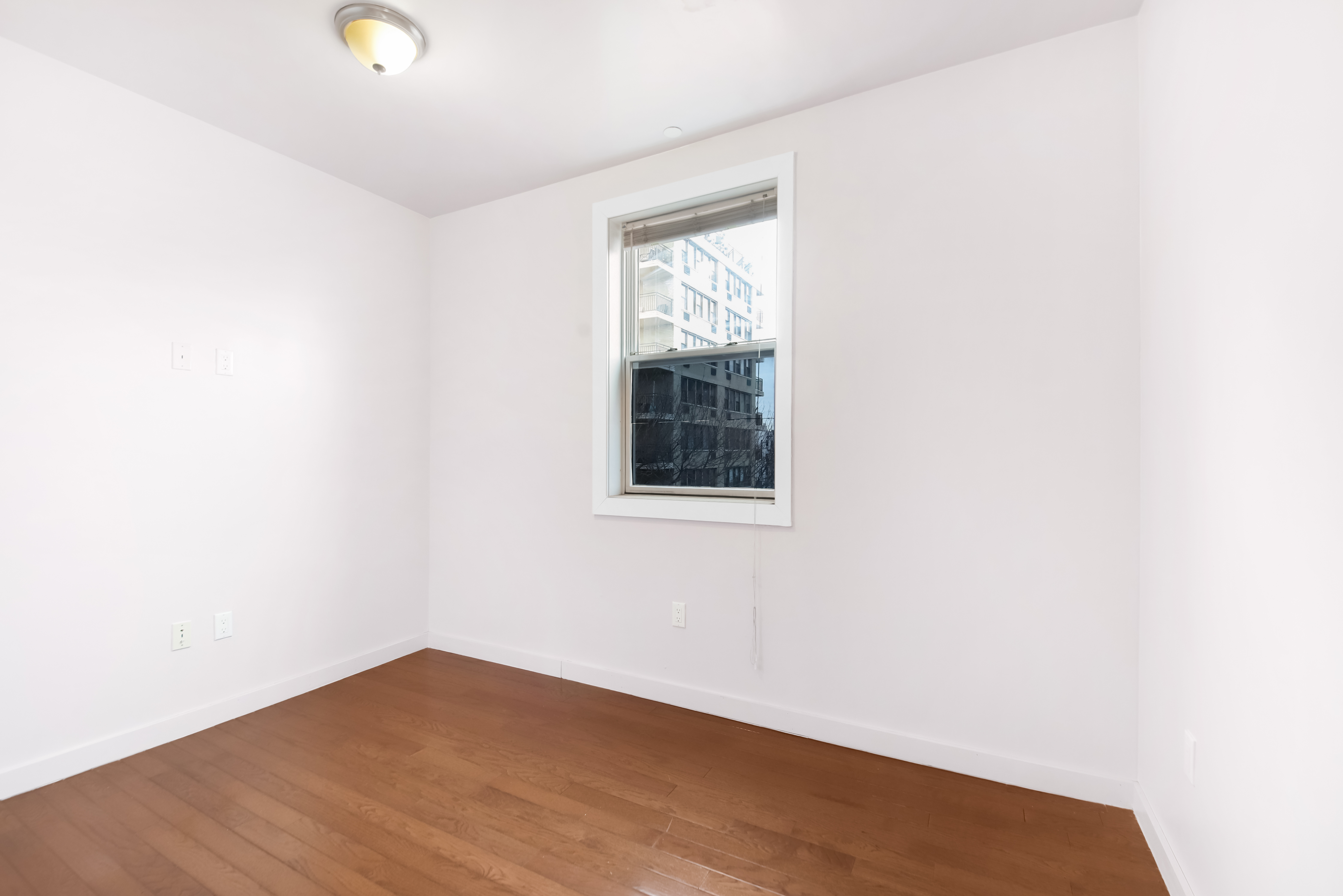 1756 Ocean Avenue, Unit 6D Brooklyn, NY 11230 - Photo 8 of 11 an empty room with wooden floor and windows