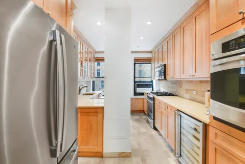 a kitchen with stainless steel appliances granite countertop a refrigerator a stove and a sink