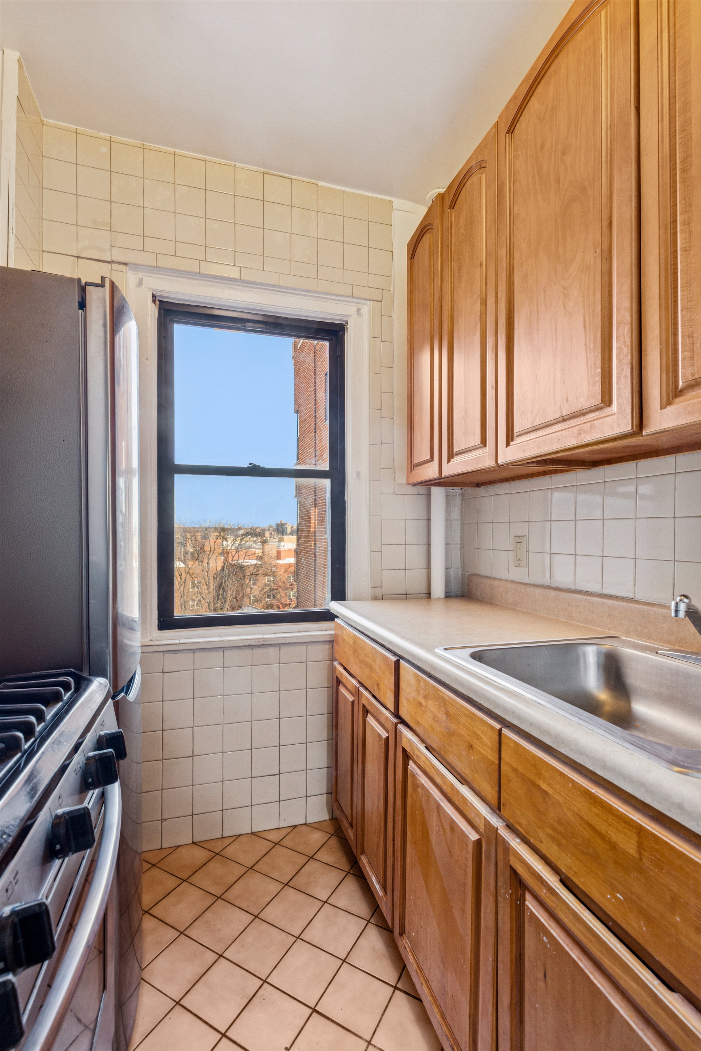 70 Park Terrace West, Unit E74 Manhattan, NY 10034 - Photo 10 of 27 a kitchen with sink cabinets and window