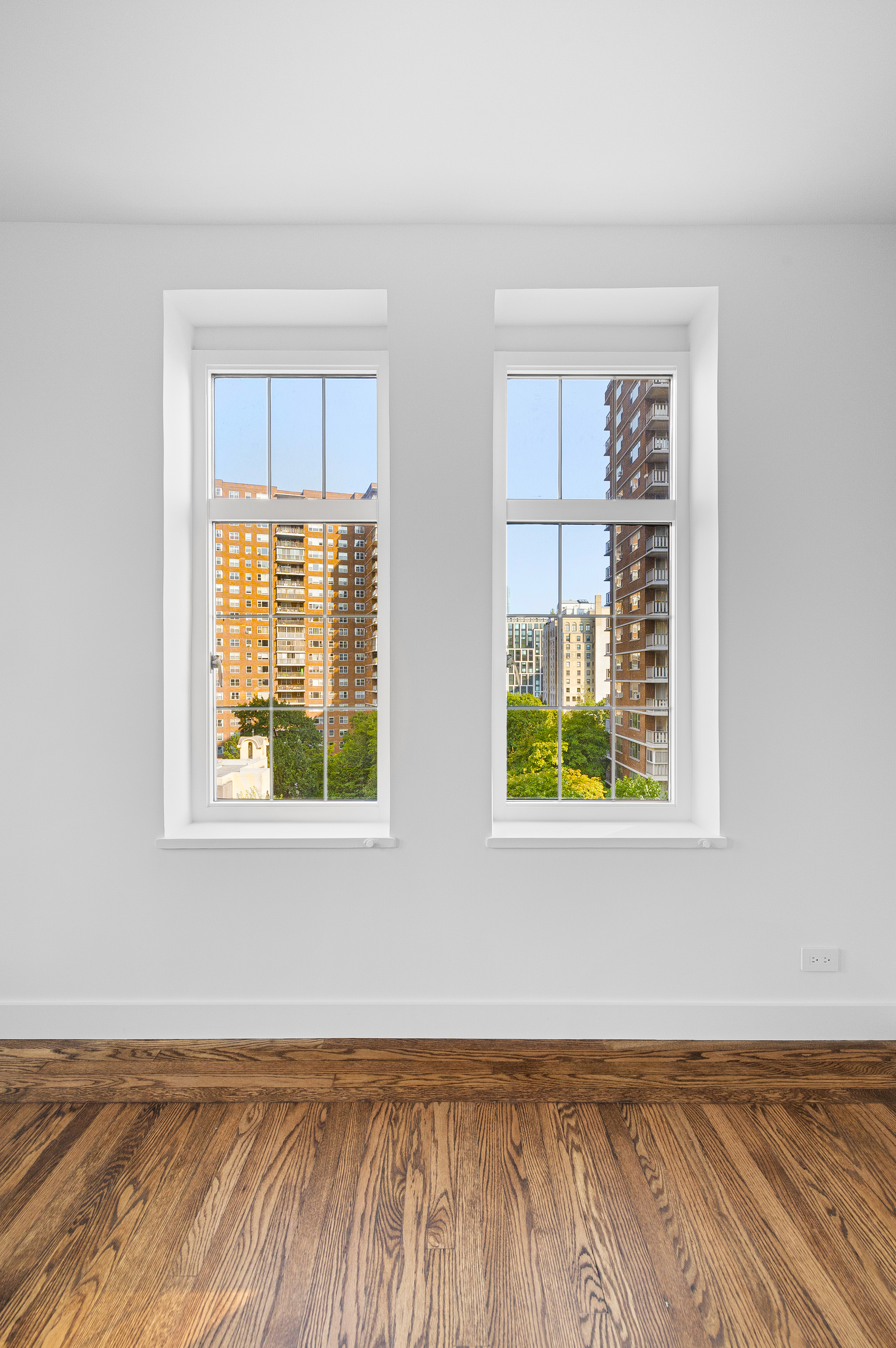 410 West 24th Street, Unit 8F Manhattan, NY 10011 - Photo 7 of 16 an empty room with wooden floor and windows