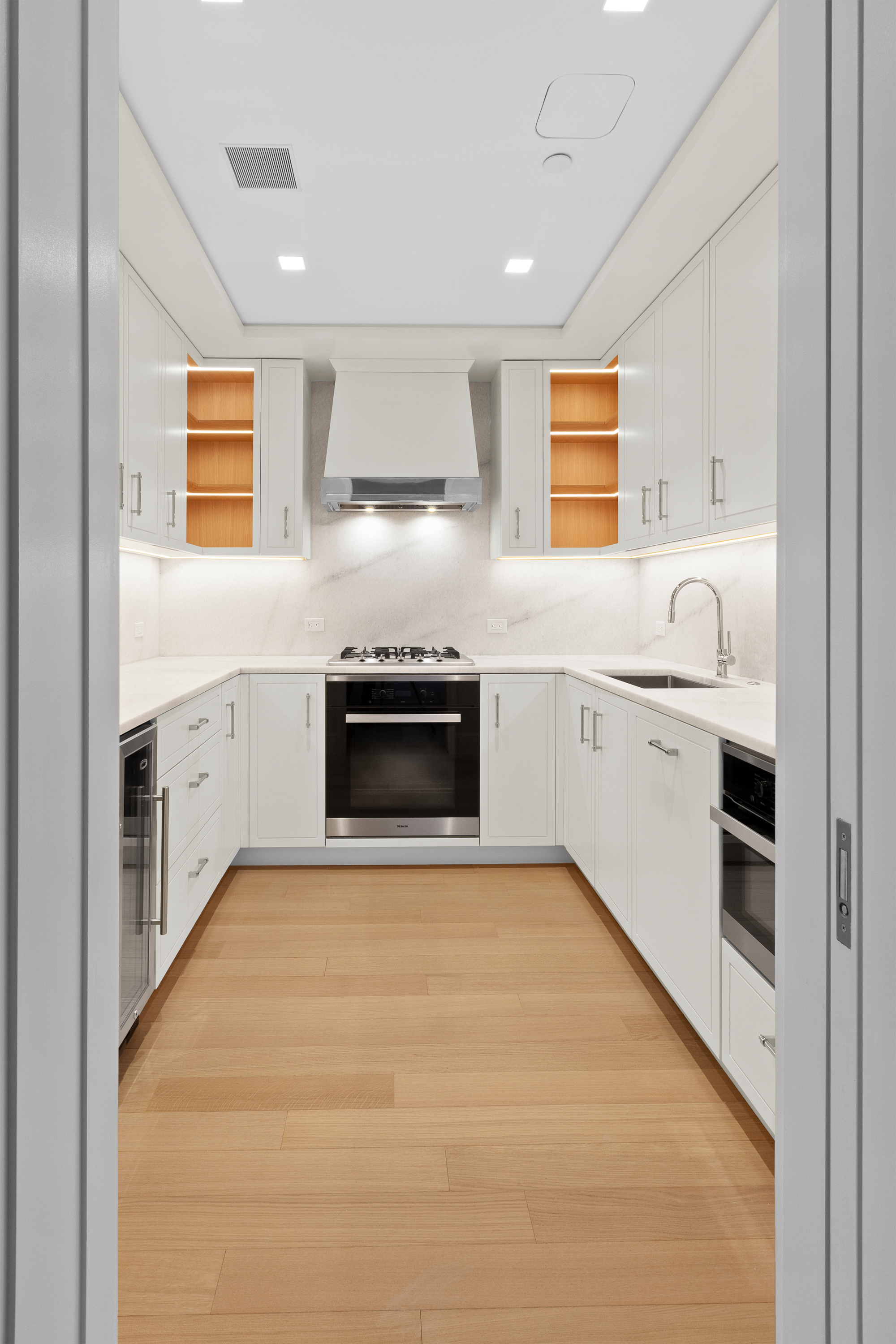 200 East 83rd Street, Unit 5D Manhattan, NY 10028 - Photo 8 of 29 a kitchen with white cabinets appliances and a sink
