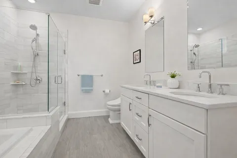 a bathroom with a sink a toilet and shower