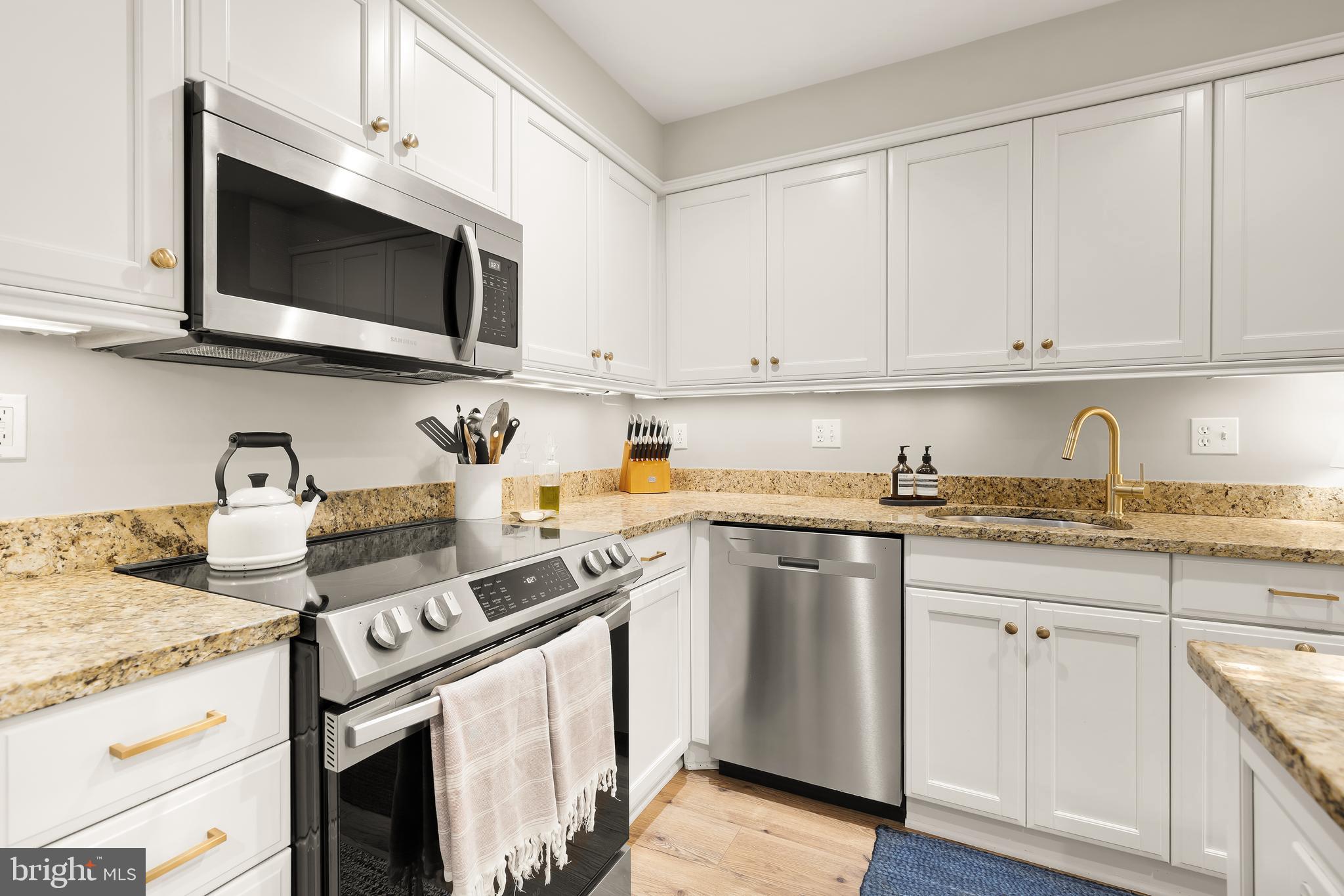 1354 Kenyon Street Northwest, Unit G Washington, DC 20010 - Photo 18 of 37 a kitchen with stainless steel appliances granite countertop a sink a stove and a microwave