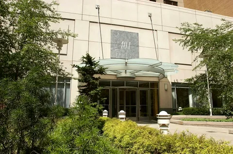 a front view of a building with a garden and plants