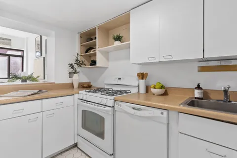 a kitchen with cabinets appliances a sink and a counter top