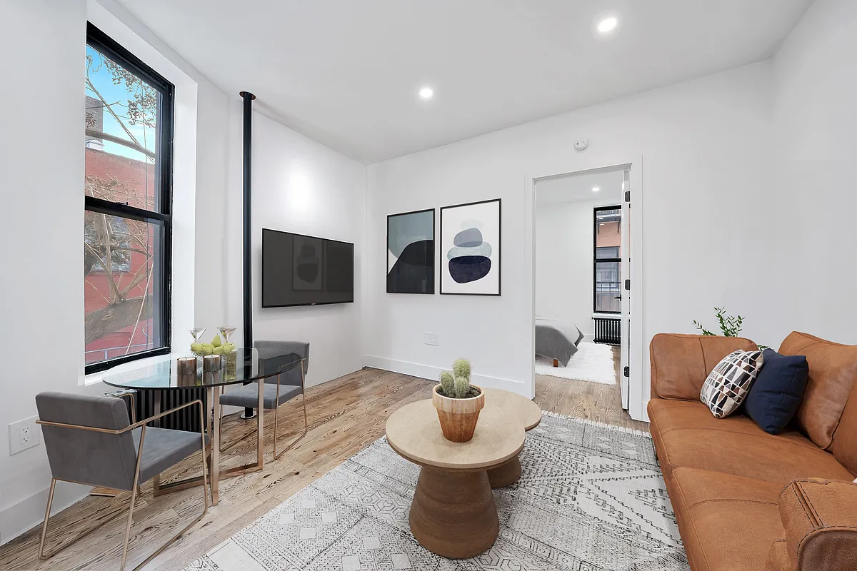 66 West 138th Street, Unit 1A Manhattan, NY 10037 - Photo 1 of 6 a living room with furniture and a flat screen tv