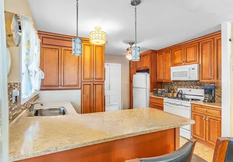 a kitchen with stainless steel appliances granite countertop a sink a stove and a refrigerator