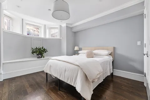 a bedroom with a bed and a potted plant