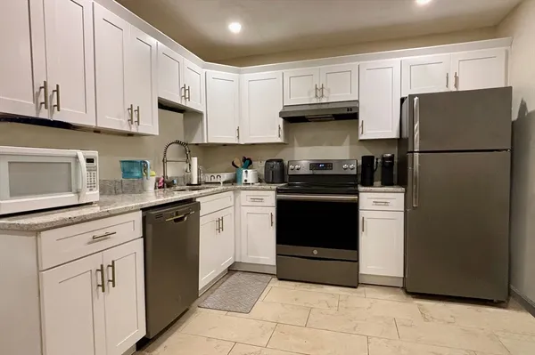 a kitchen with cabinets and stainless steel appliances