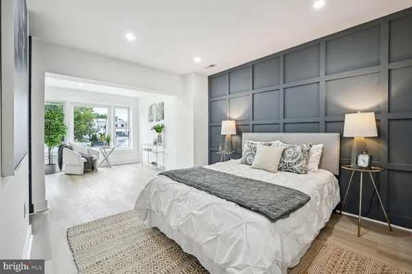 a spacious bedroom with a bed a couch and a chandelier