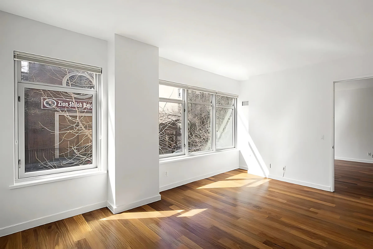 181 Clermont Avenue, Unit 101 Brooklyn, NY 11205 - Photo 2 of 9 an empty room with wooden floor and windows