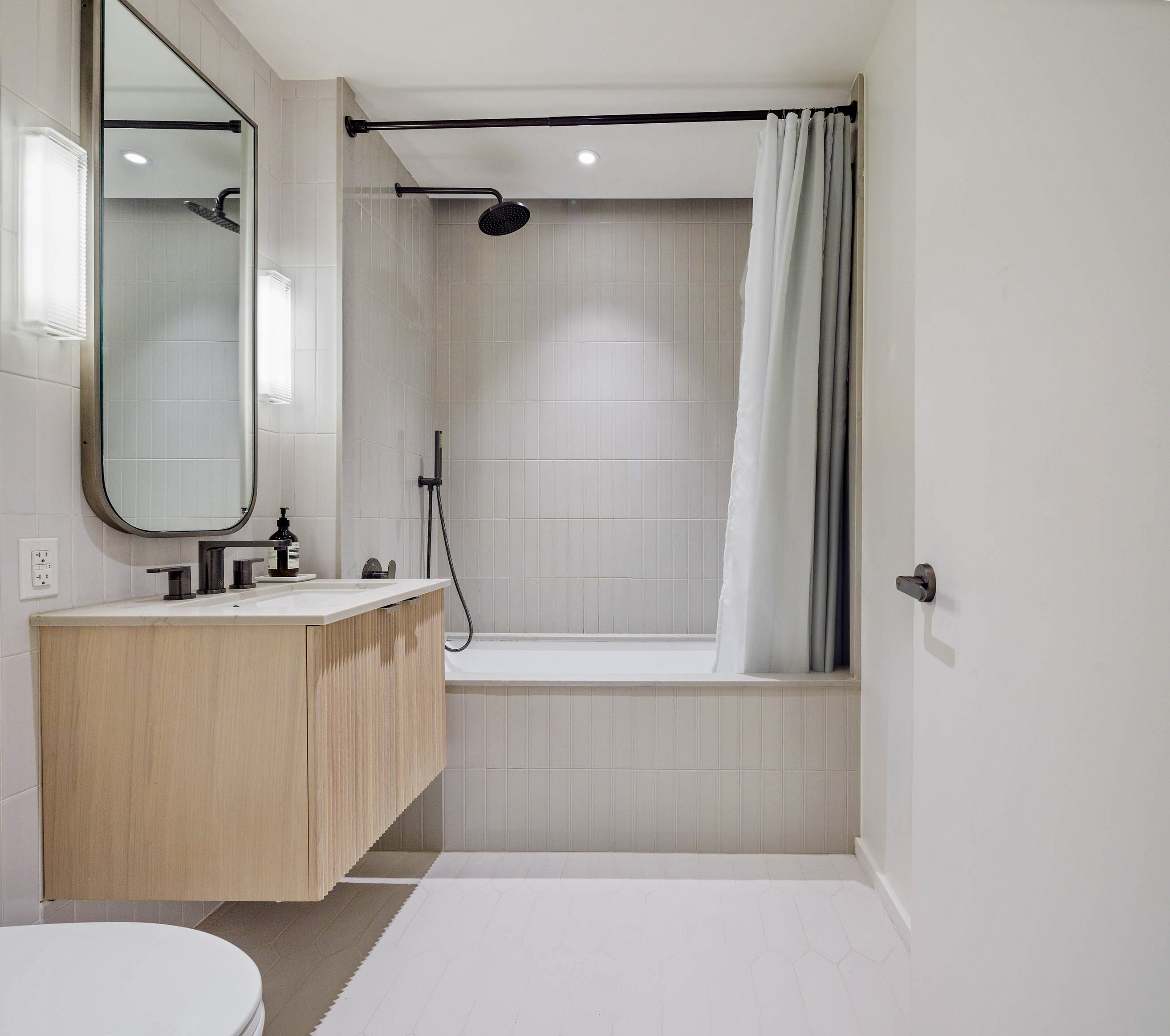 58 St Marks Place, Unit 212 Brooklyn, NY 11217 - Photo 14 of 27 a bathroom with a tub a sink and a mirror