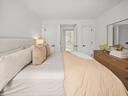 a spacious bedroom with a bed and ceiling fan