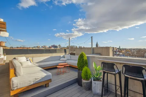 a view of roof deck with seating space and barbeque oven