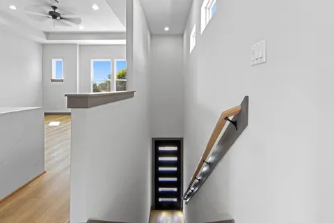 a view of a hallway with wooden floor and staircase