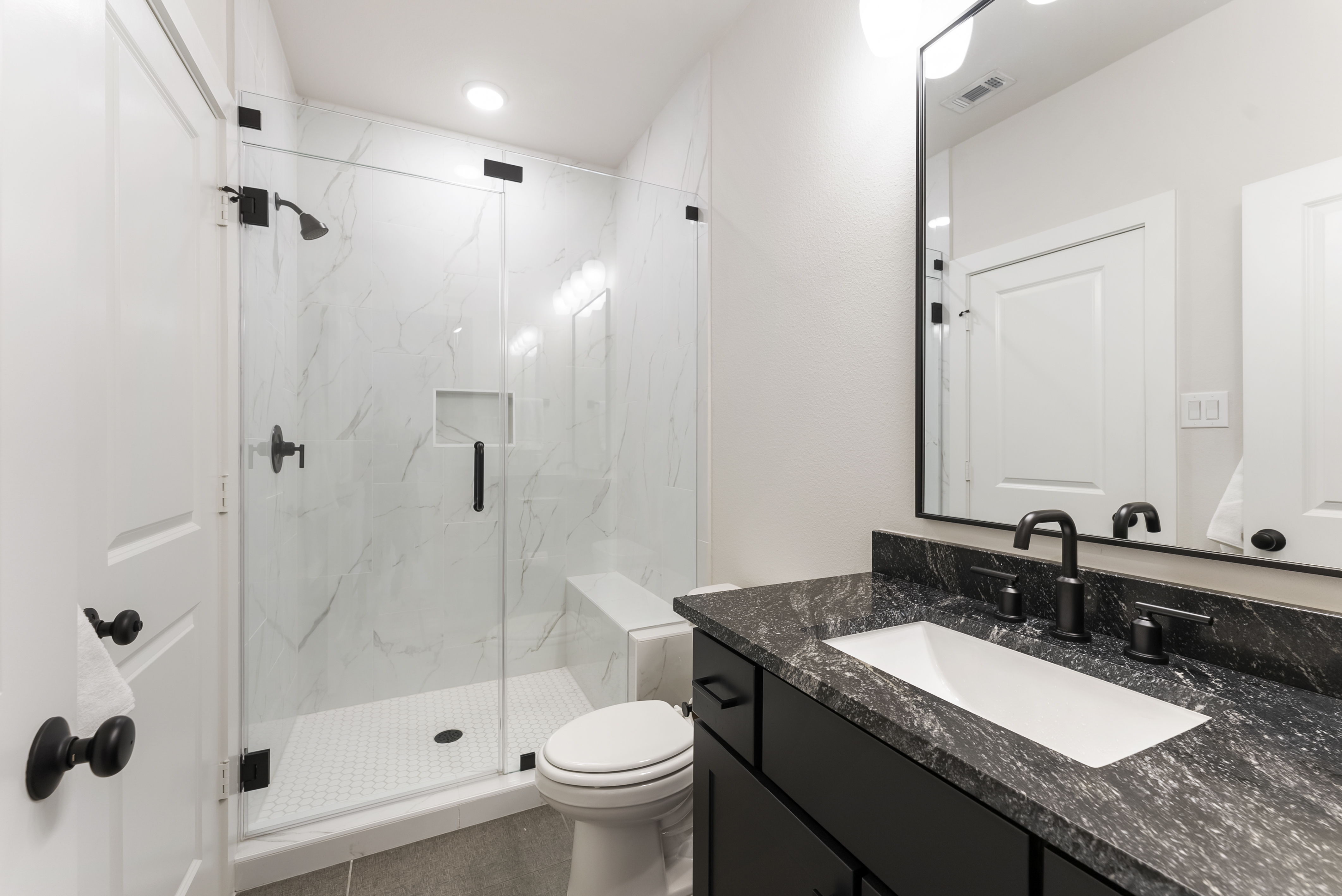 2118 Bennet Court Conroe, TX 77384 - Photo 57 of 70 a bathroom with a granite countertop sink a toilet a mirror and shower