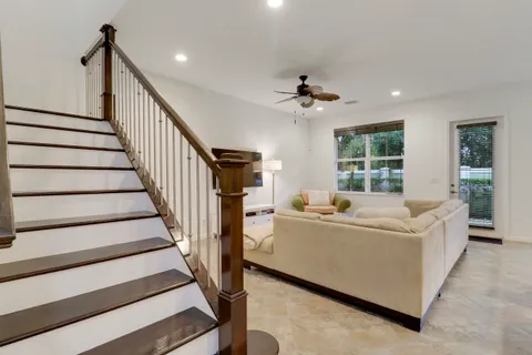 a living room with furniture and a ceiling fan