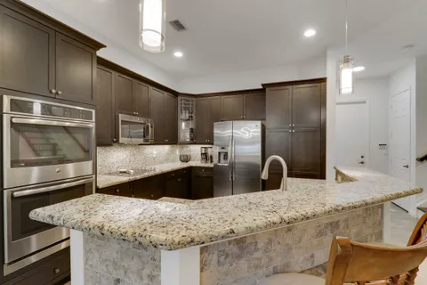 a kitchen with stainless steel appliances granite countertop a sink and a refrigerator