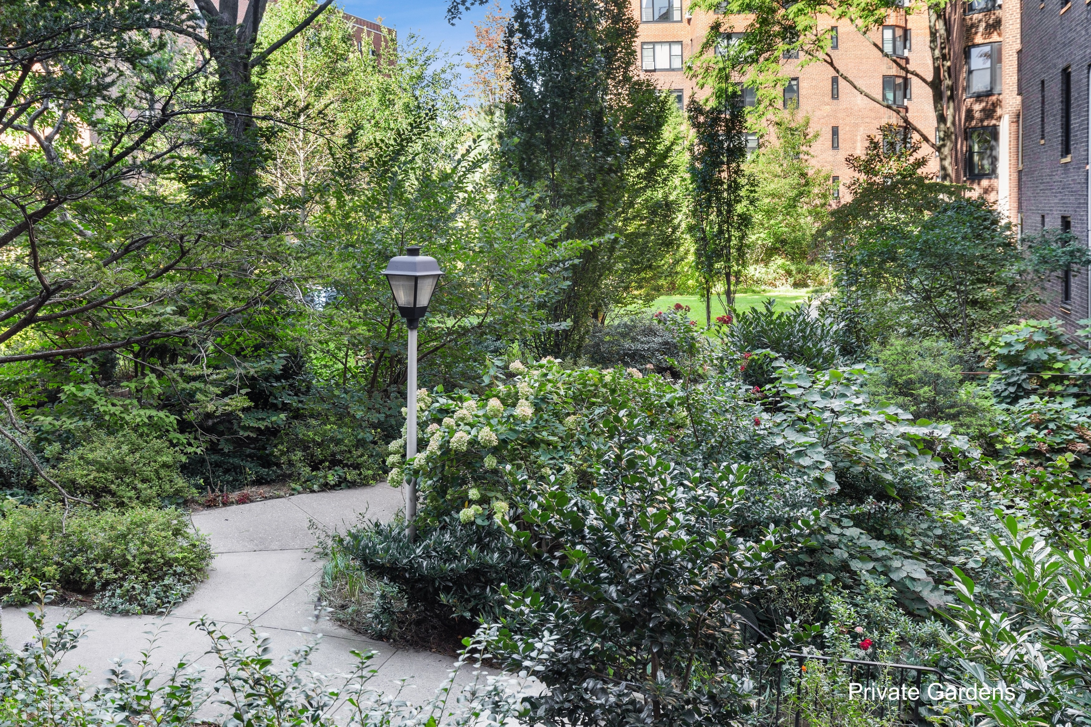 70 Park Terrace West, Unit E74 Manhattan, NY 10034 - Photo 18 of 27 a view of a street with flower plants and tree next to a road