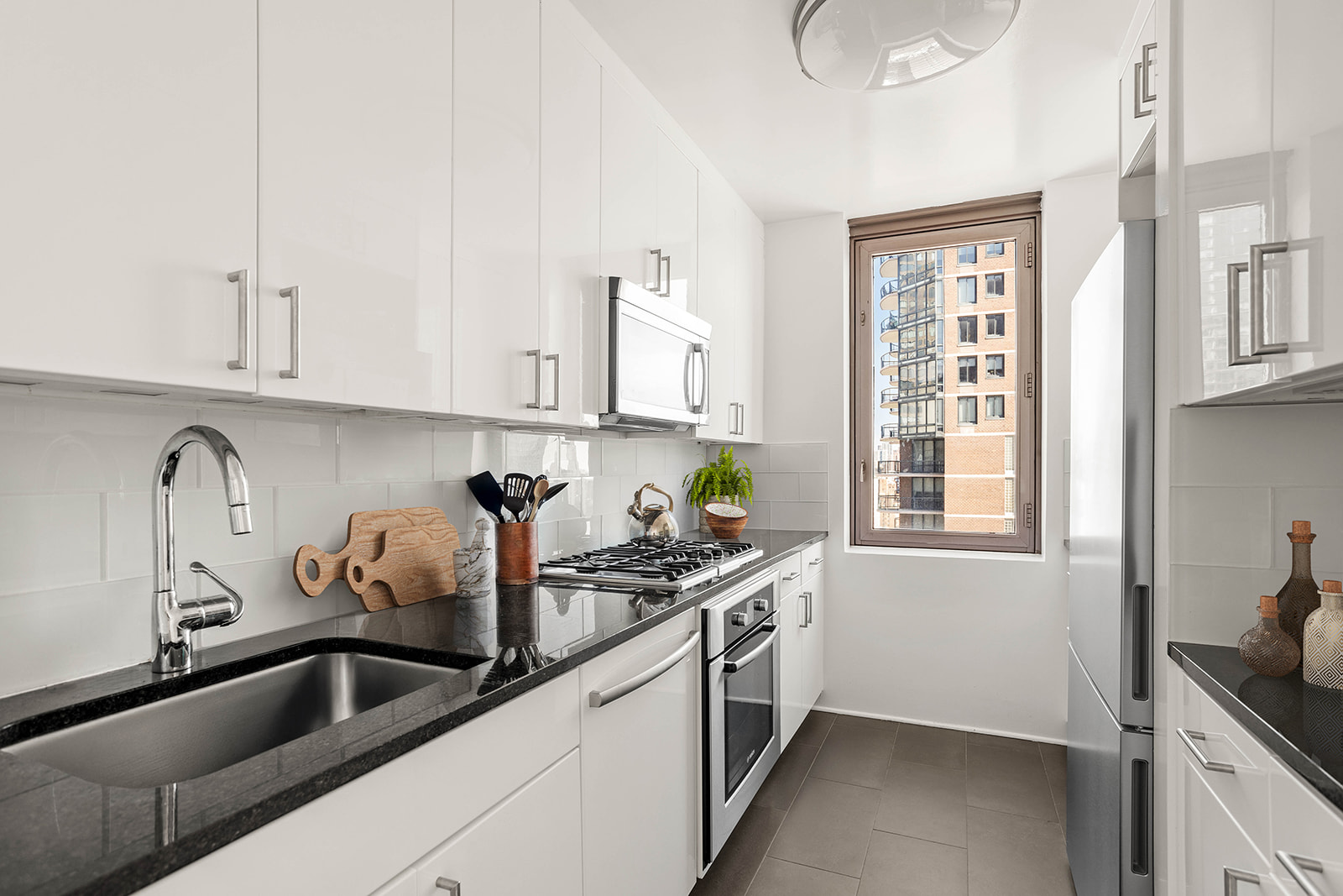 300 East 64th Street, Unit 26B Manhattan, NY 10065 - Photo 7 of 26 a kitchen that has a sink and a stove