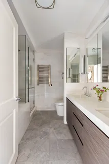 a spacious bathroom with a double vanity sink a large mirror and a shower