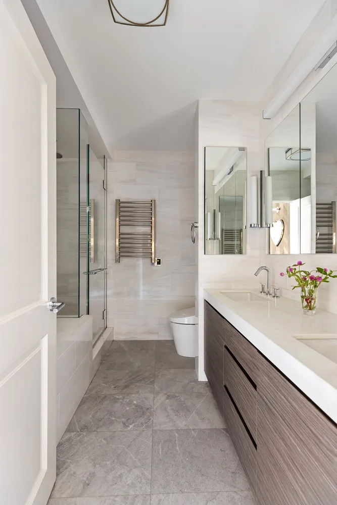 a spacious bathroom with a double vanity sink a large mirror and a shower