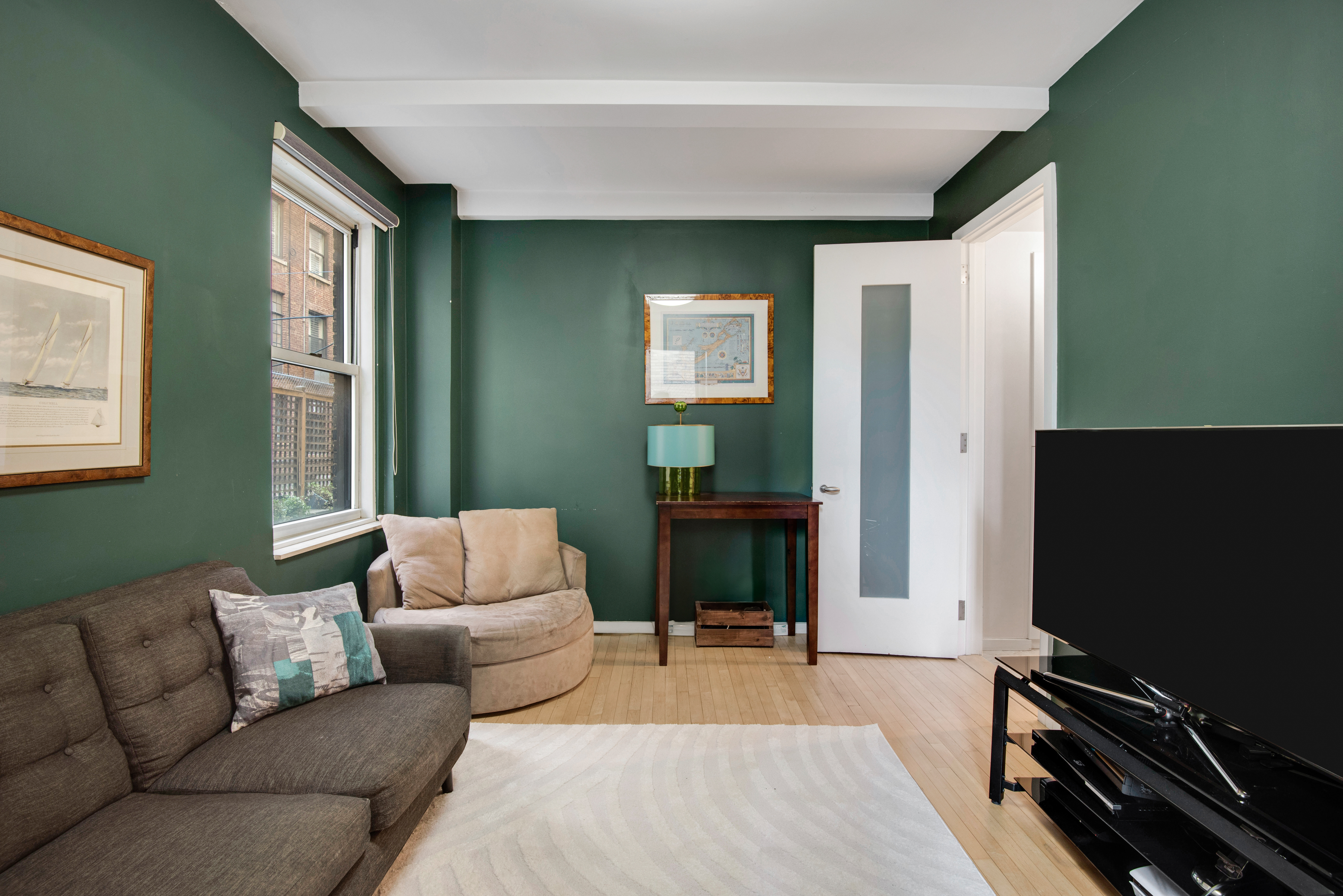 434 East 52nd Street, Unit 1BH Manhattan, NY 10022 - Photo 15 of 23 a living room with furniture and a flat screen tv