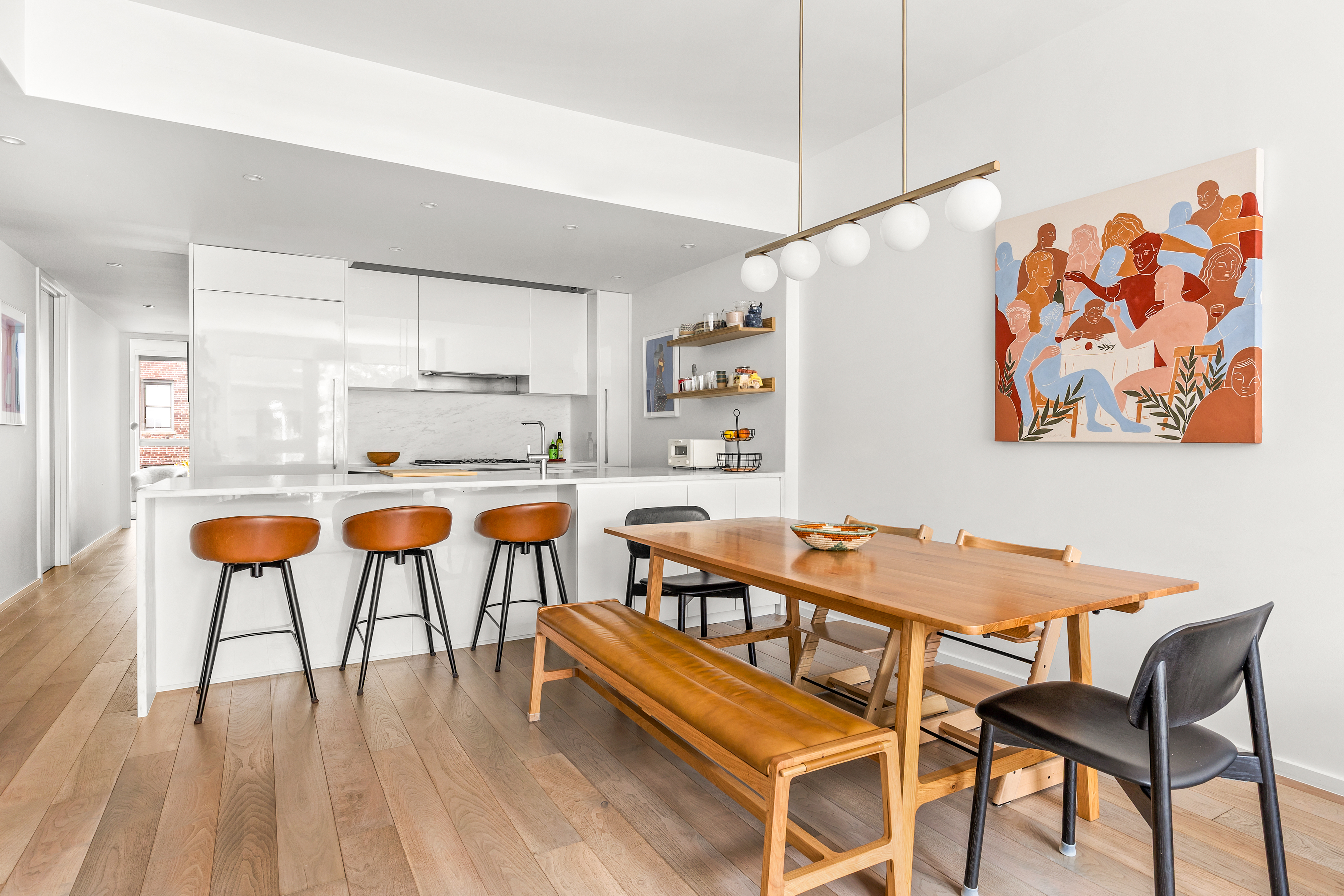 150 East 23rd Street, Unit 3C Manhattan, NY 10010 - Photo 2 of 12 a kitchen with stainless steel appliances kitchen island a table and chairs in it