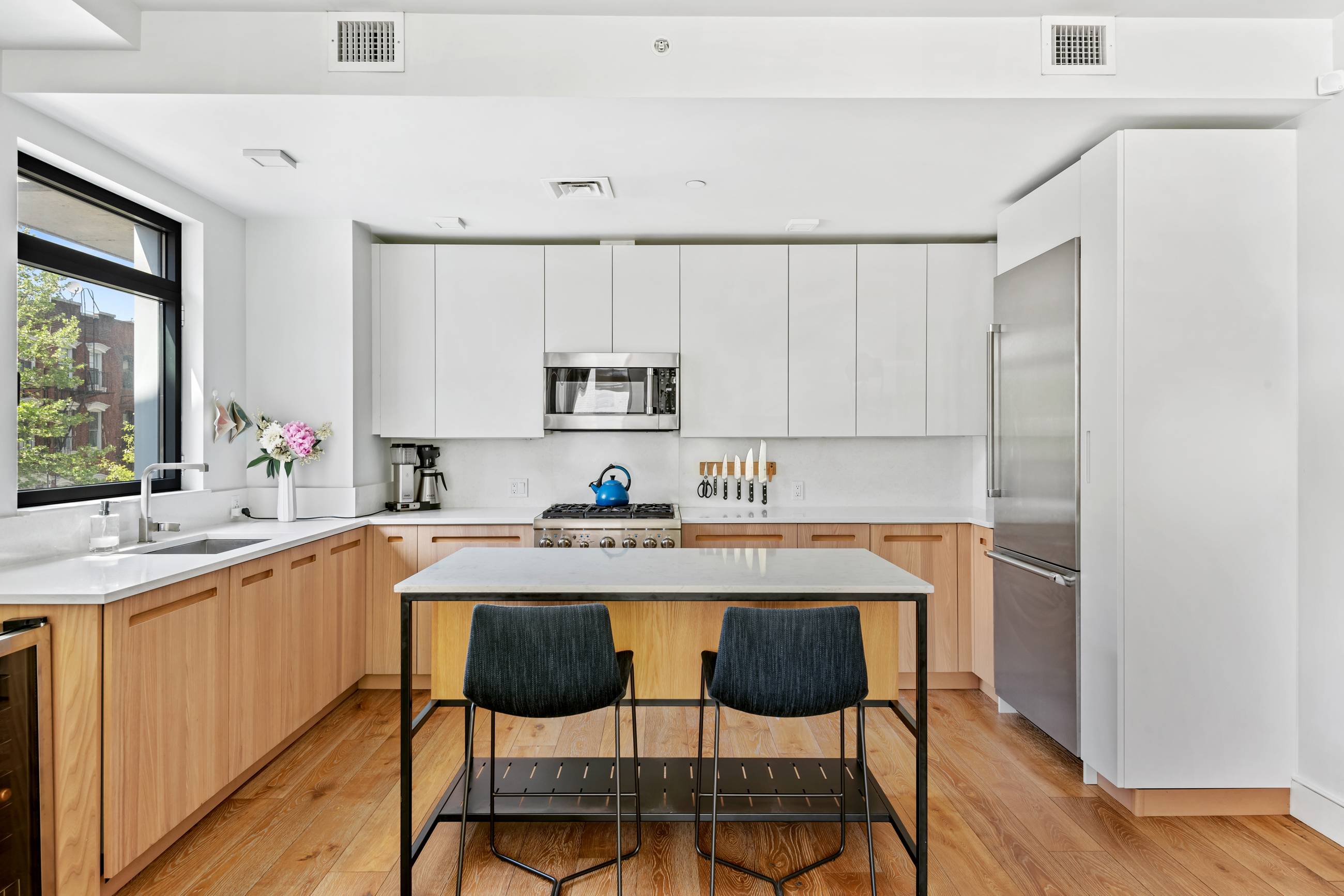 147 Hope Street, Unit 2D Brooklyn, NY 11211 - Photo 2 of 13 a kitchen with a sink chairs and cabinets