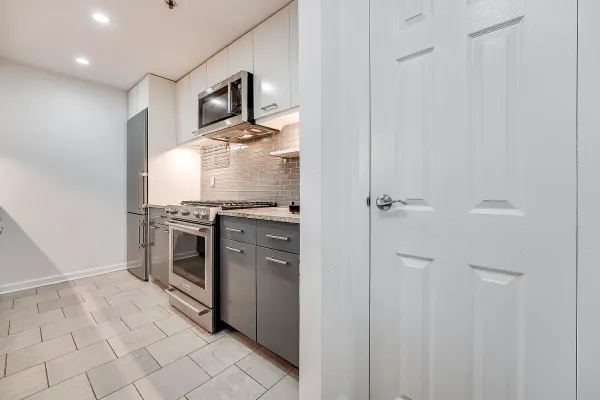 a kitchen with stainless steel appliances a stove top oven and cabinets