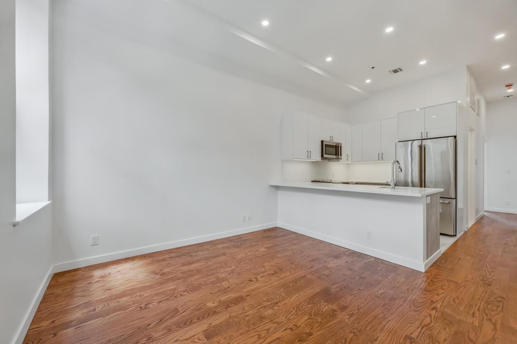 a kitchen with cabinets and wooden floor