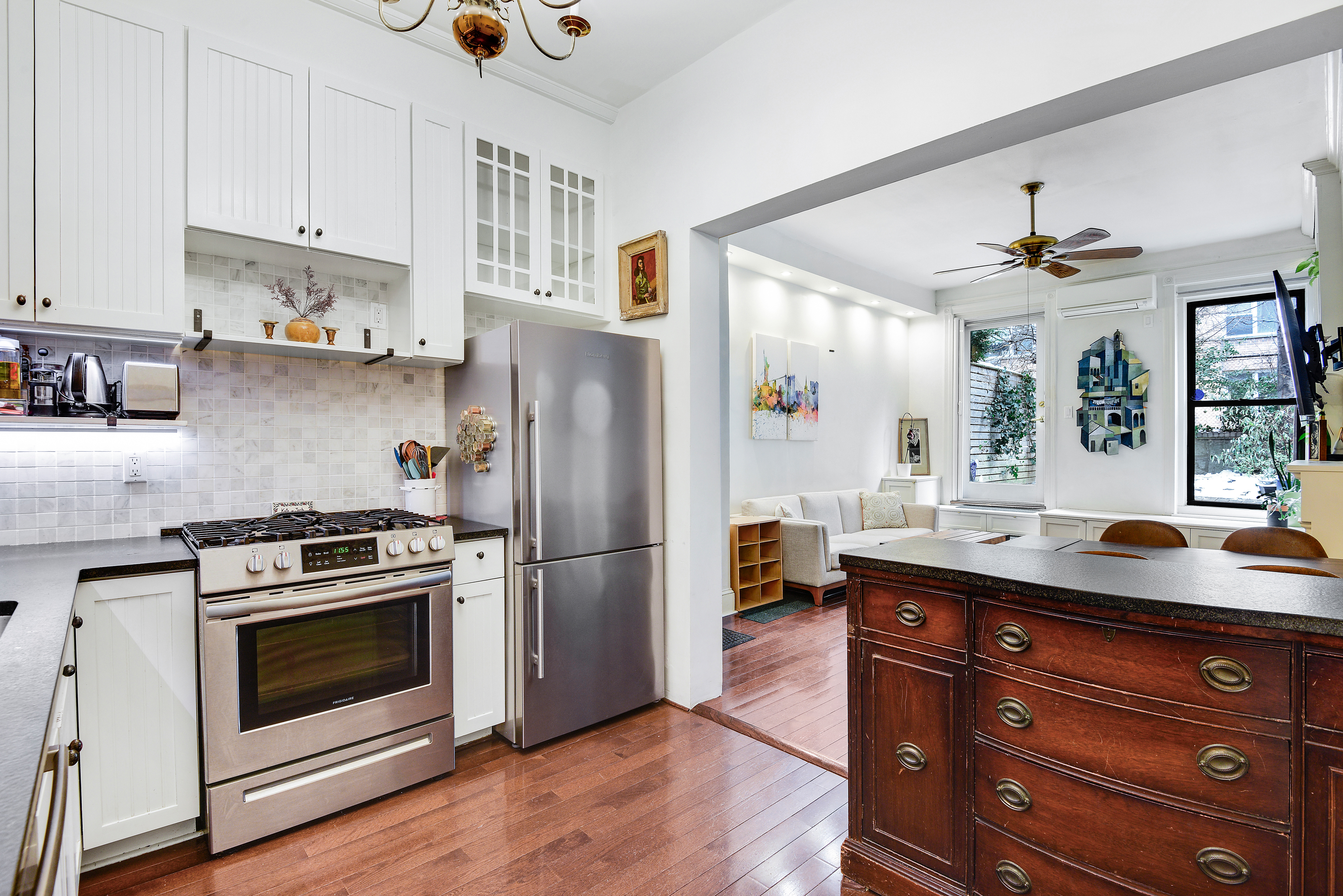 436 East 66th Street, Unit 1W Manhattan, NY 10065 - Photo 7 of 19 a kitchen with stainless steel appliances granite countertop a stove a refrigerator and a sink with wooden floors