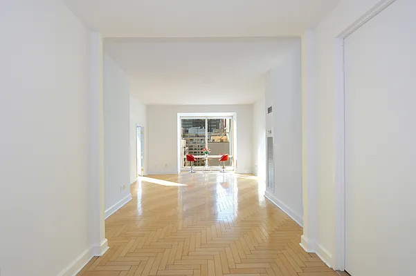 845 United Nations Plaza, Unit 56E Manhattan, NY 10017 - Photo 8 of 28 a view of an empty room with wooden floor and a window