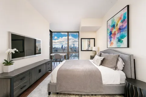 a bedroom with a bed and a large window