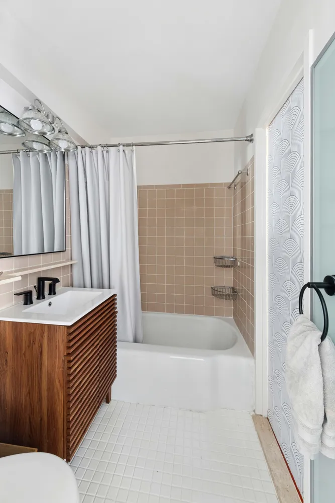 a bathroom with a sink a toilet and shower