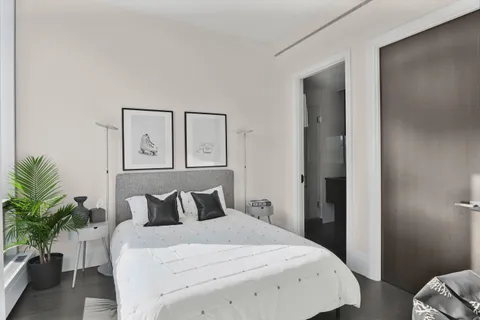 a bedroom with a bed and a potted plant