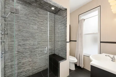 a bathroom with a sink a toilet and shower
