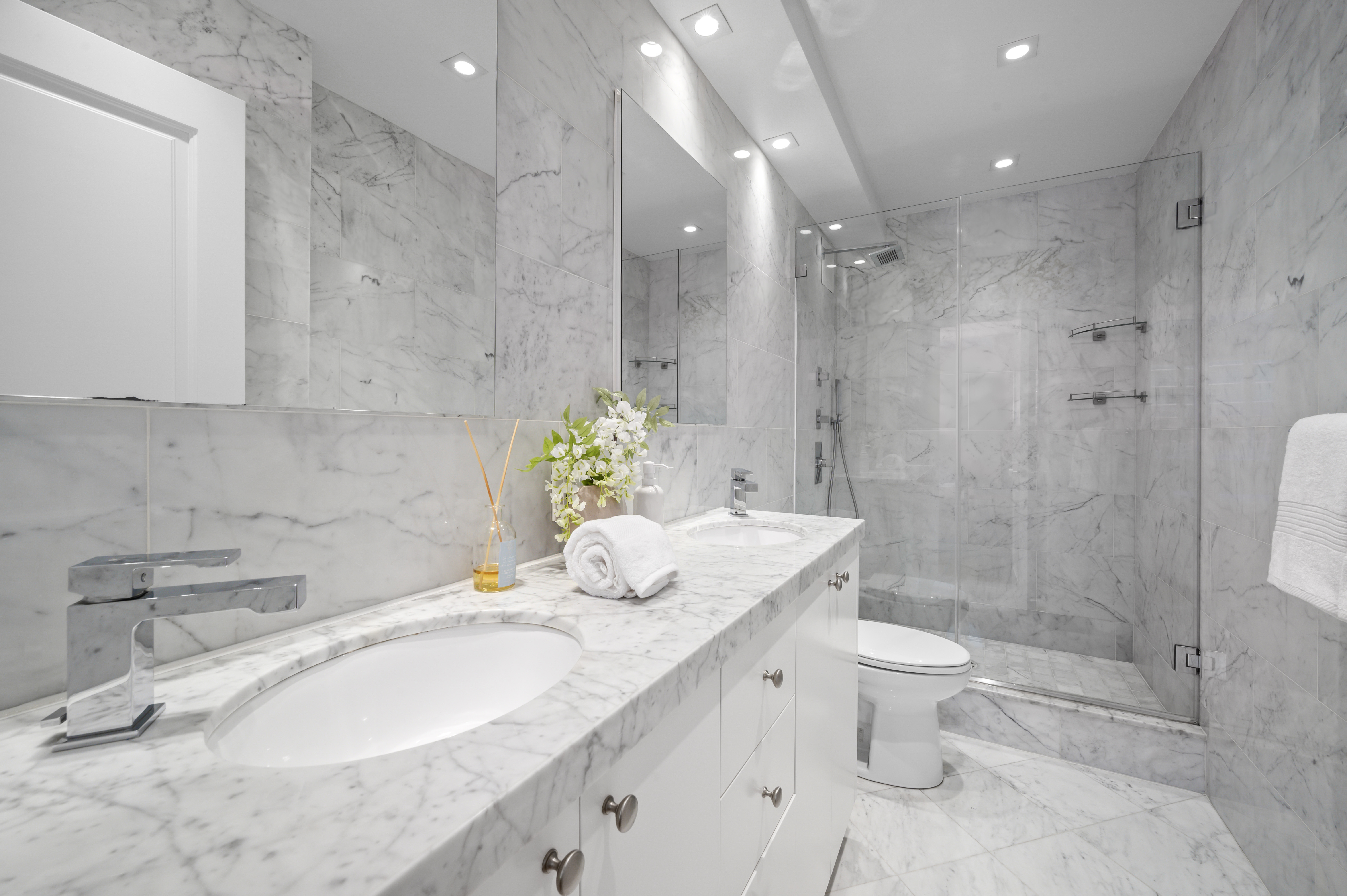 166 East 63rd Street, Unit 2J Manhattan, NY 10065 - Photo 11 of 14 a bathroom with a granite countertop sink a toilet and shower