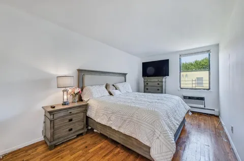 a bedroom with a bed and flat tv screen on a dresser