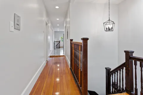 a view of a hallway with wooden floor