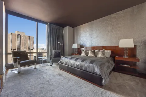 a spacious bedroom with a bed and large windows